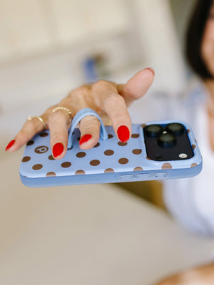A woman holding a Blue Polka Dots Loopy Case. || feature-media