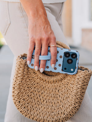 A woman holding a Blue Polka Dots Loopy Case. || feature-media
