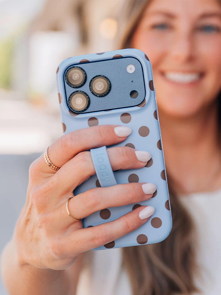 A woman holding a Blue Polka Dots Loopy Case. || feature-media