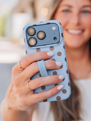 A woman holding a Blue Polka Dots Loopy Case. || feature-media