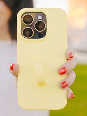 A woman holding a Butter Yellow Loopy Case. || feature-media