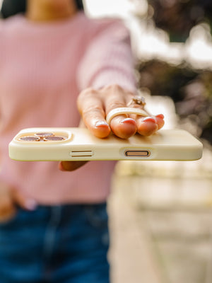 A woman holding a Butter Yellow Loopy Case. || feature-media