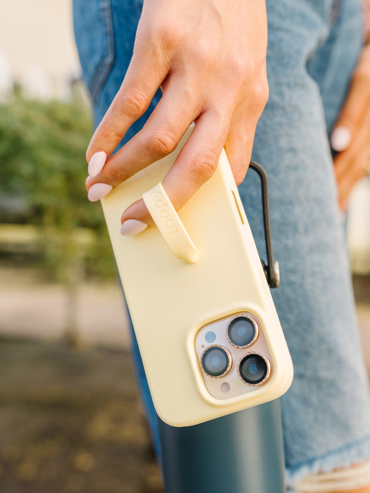 A woman holding a Butter Yellow Loopy Case. || feature-media