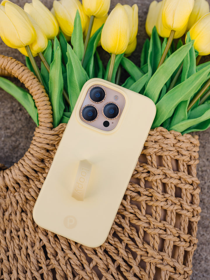 A woman holding a Butter Yellow Loopy Case. || feature-media