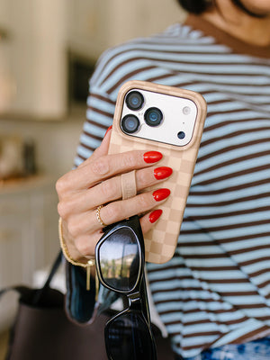 A woman holding a Caramel Checkered Loopy Case. || feature-media
