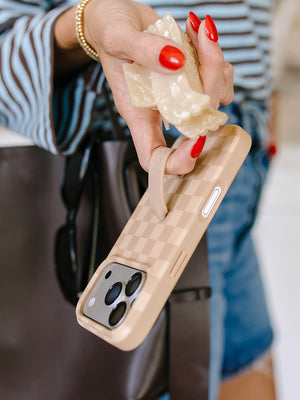 A woman holding a Caramel Checkered Loopy Case. || feature-media