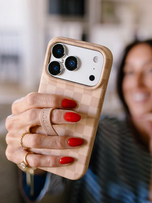 A woman holding a Caramel Checkered Loopy Case. || feature-media