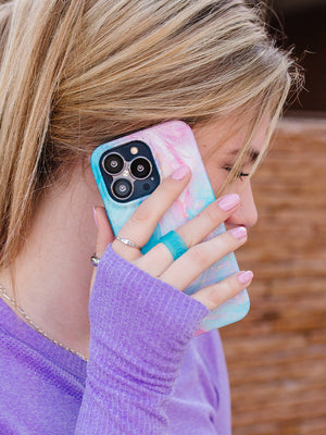 A women talking on the phone while holding a Cotton Candy Swirl Loopy Case. || feature-media