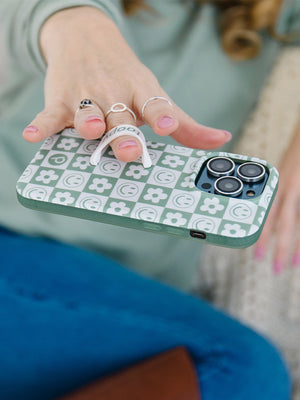 A woman holding a Groovy Sage Checkered Loopy Case. || feature-media