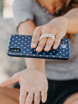 A woman holding a Navy Polka Dot Loopy Case. || feature-media