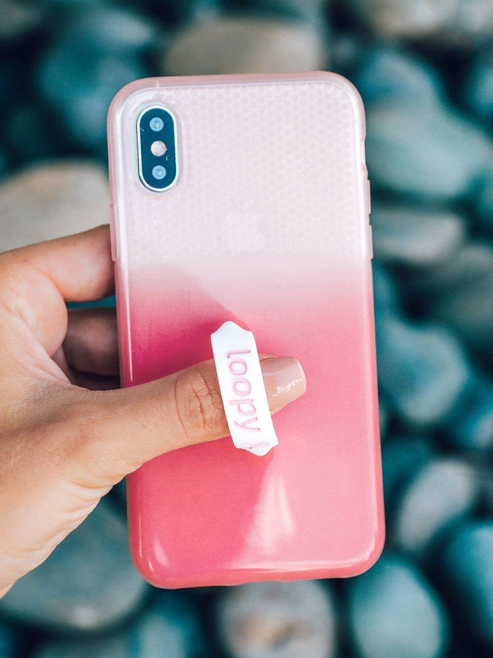 A woman holding a Pink Ombre Loopy Case. 