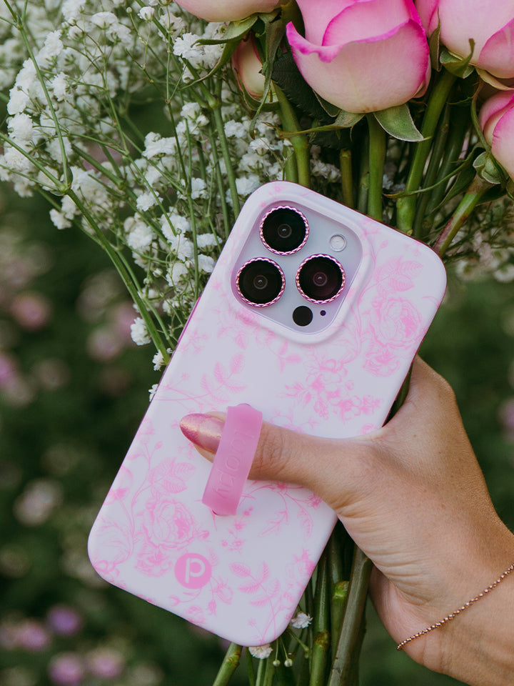 A woman holding a Pink Toile Loopy Case. 