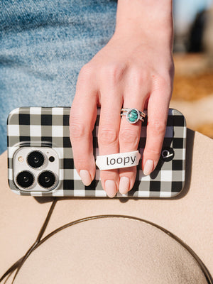 A woman holding a Plaid Loopy Case.|| feature-media