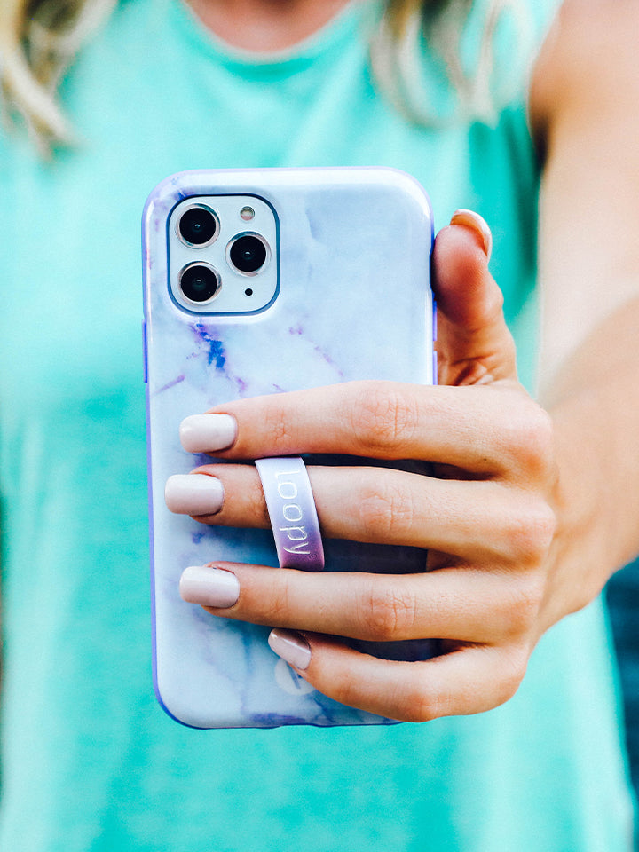 A woman holding a Purple Marble Loopy Case. 