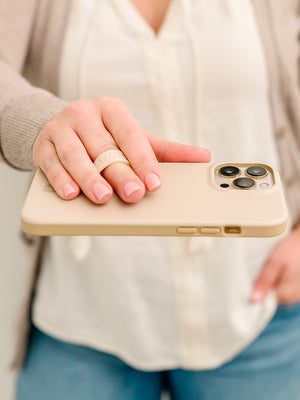 A woman holding a Sandstone Loopy Case. || feature-media