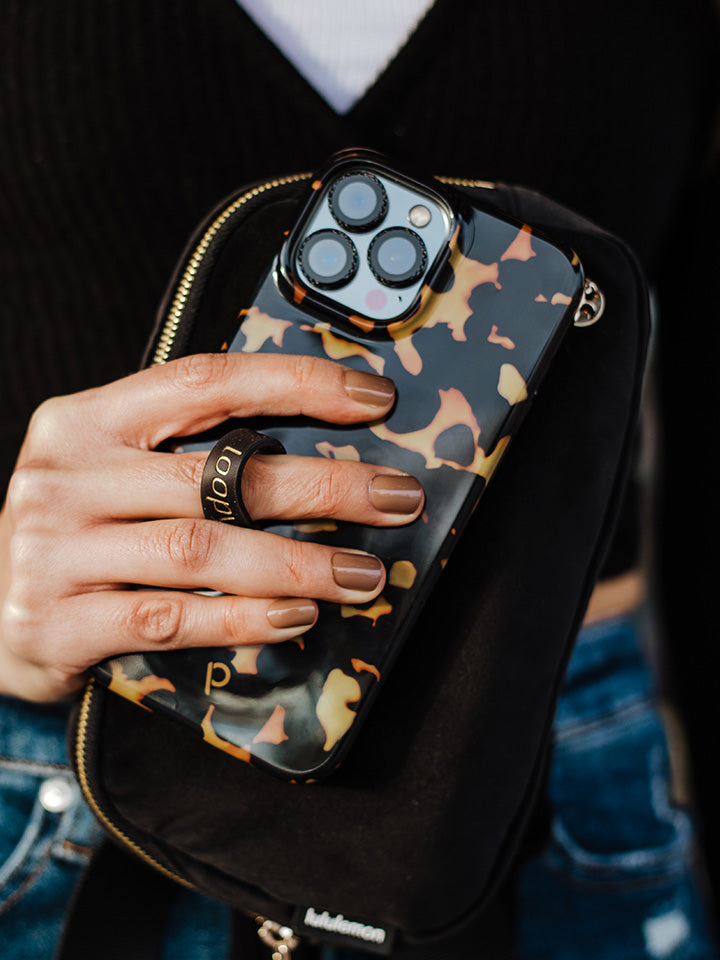 A woman holding a Tortoise Loopy Case. || feature-media
