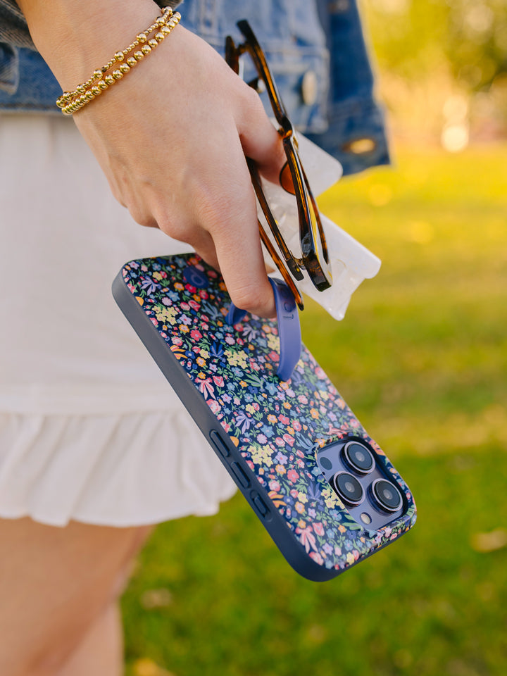  A woman holding a Whimsy Garden Loopy Case.|| feature-media