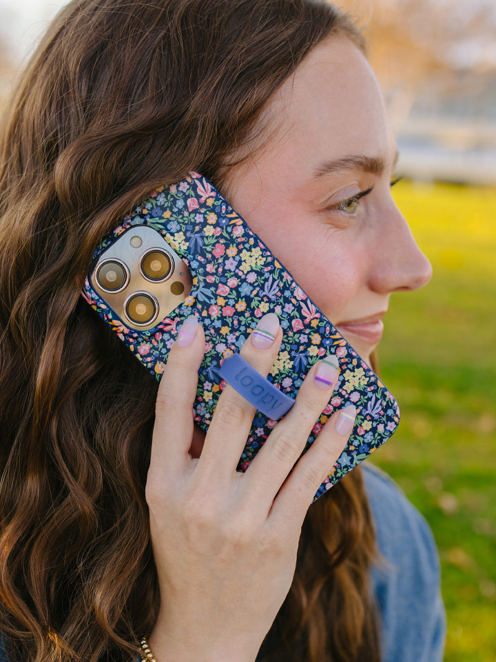 A woman talking on the phone while using a Whimsy Garden Loopy Case. || feature-media
