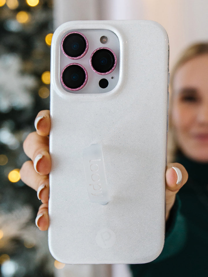 A woman holding a White Shimmer Loopy Case. || feature-media