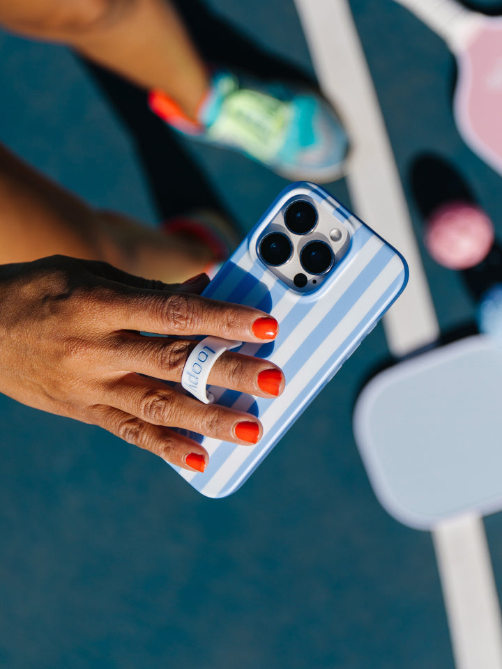 A woman holding a Blue Stripes Loopy Case. || feature-media