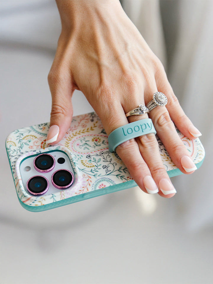 A woman holding a Painted Paisley Loopy Case. 