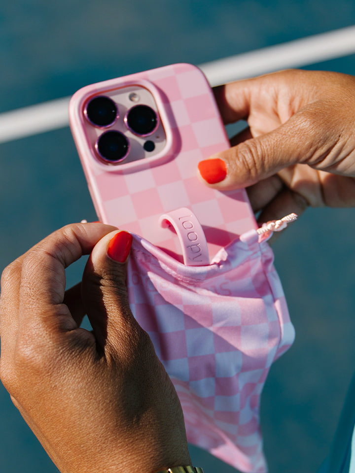 A woman holding a Blush Checkered Loopy Case. || feature-media