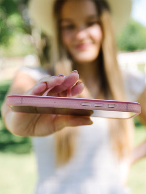 A woman holding a Cowgirl Charm Loopy Case. || feature-media