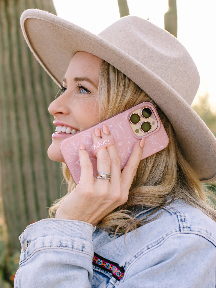 A woman holding a Cowgirl Charm Loopy Case. || feature-media