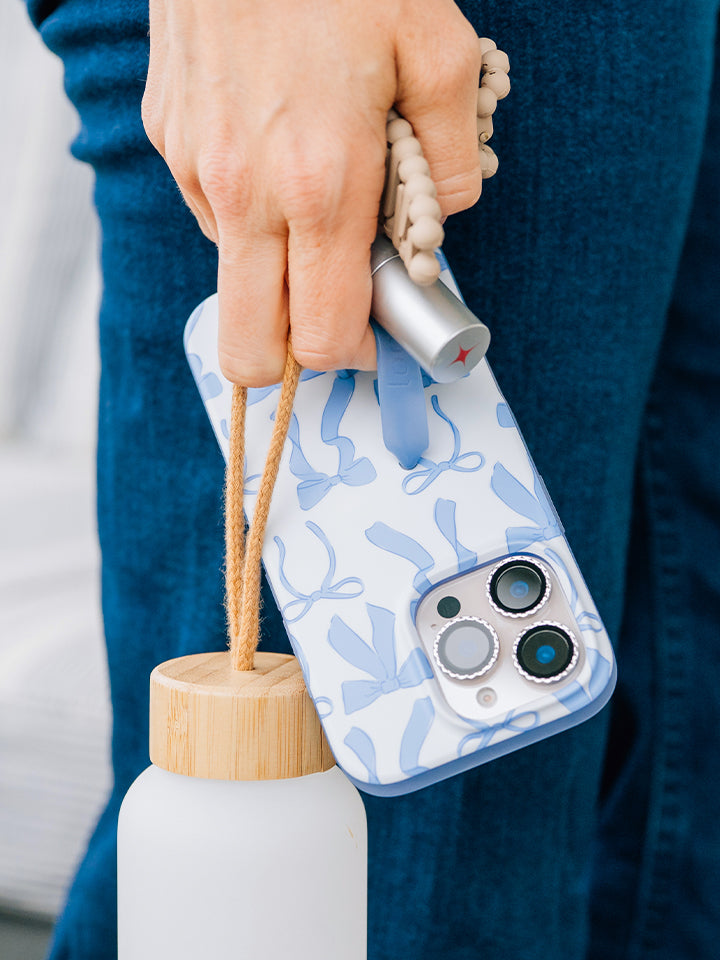 A woman holding a Blue Bows Loopy Case. || feature-media