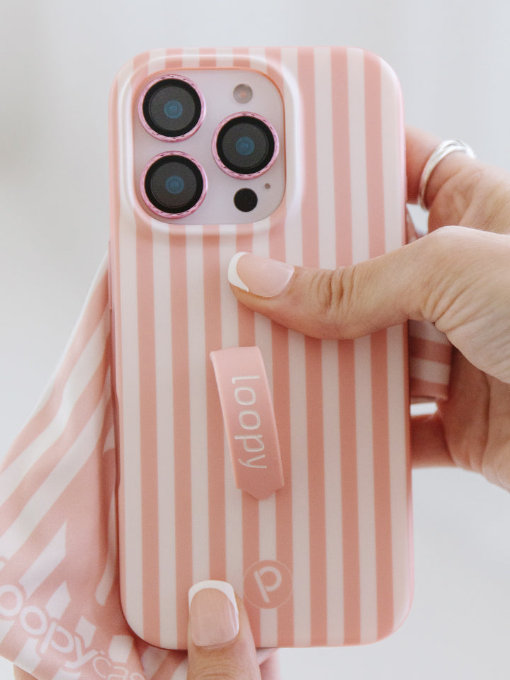 A woman holding a Terracotta Stripes Loopy Case. 
