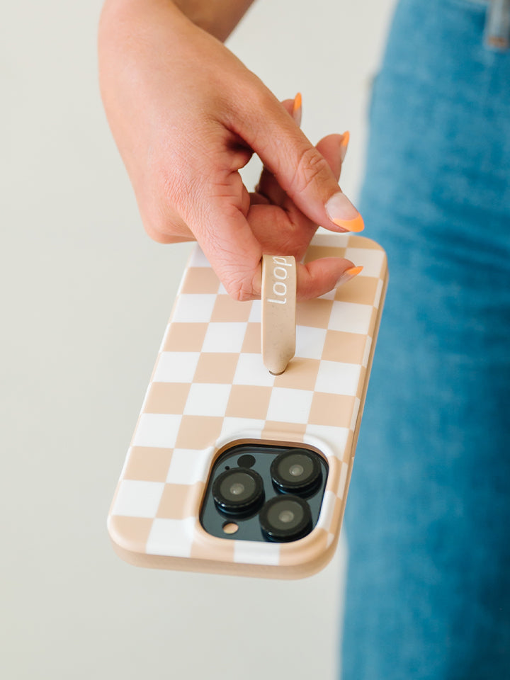 A woman holding a Sand Dollar Checkered Loopy Case. || feature-media