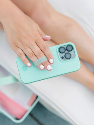 A woman holding a Mint Splash Loopy Case. || feature-media