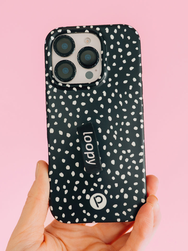 A woman holding a Noir Dots Loopy Case. || feature-media