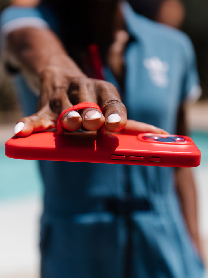 A woman holding a Red Loopy Case. || feature-media