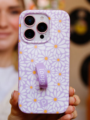 A woman holding a Daisy Daze Loopy Case. || feature-media