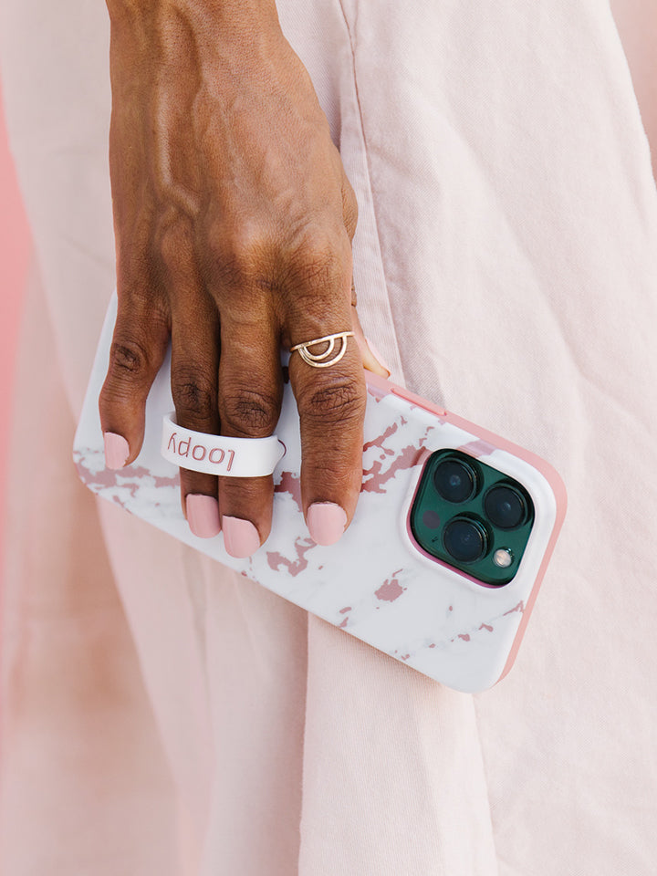 A woman holding a Rose Marble Metallic Loopy Case.|| feature-media