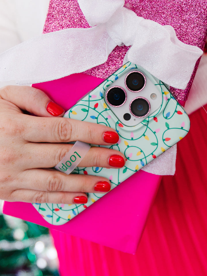 A woman holding a Merry and Bright Loopy Case. || feature-media