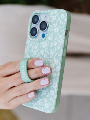 A woman holding a Sage Floral Loopy Case. || feature-media