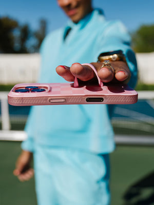 A woman holding a Blush Checkered Loopy Case. || feature-media
