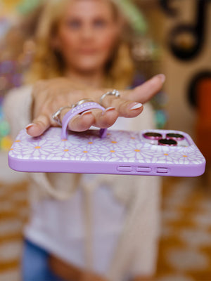 A woman holding a Daisy Daze Loopy Case. || feature-media