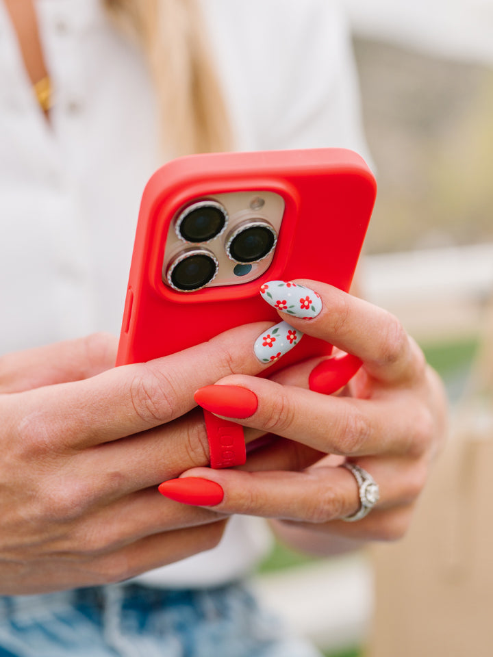 A woman holding a Red Loopy Case. || feature-media