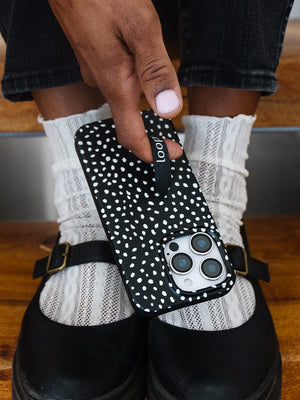 A woman holding a Noir Dots Loopy Case. || feature-media
