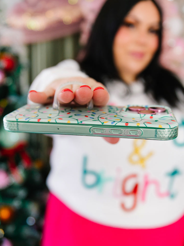 A woman holding a Merry and Bright Loopy Case. || feature-media