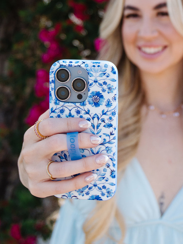 A woman holding a Blue Willow Loopy Case. || feature-media