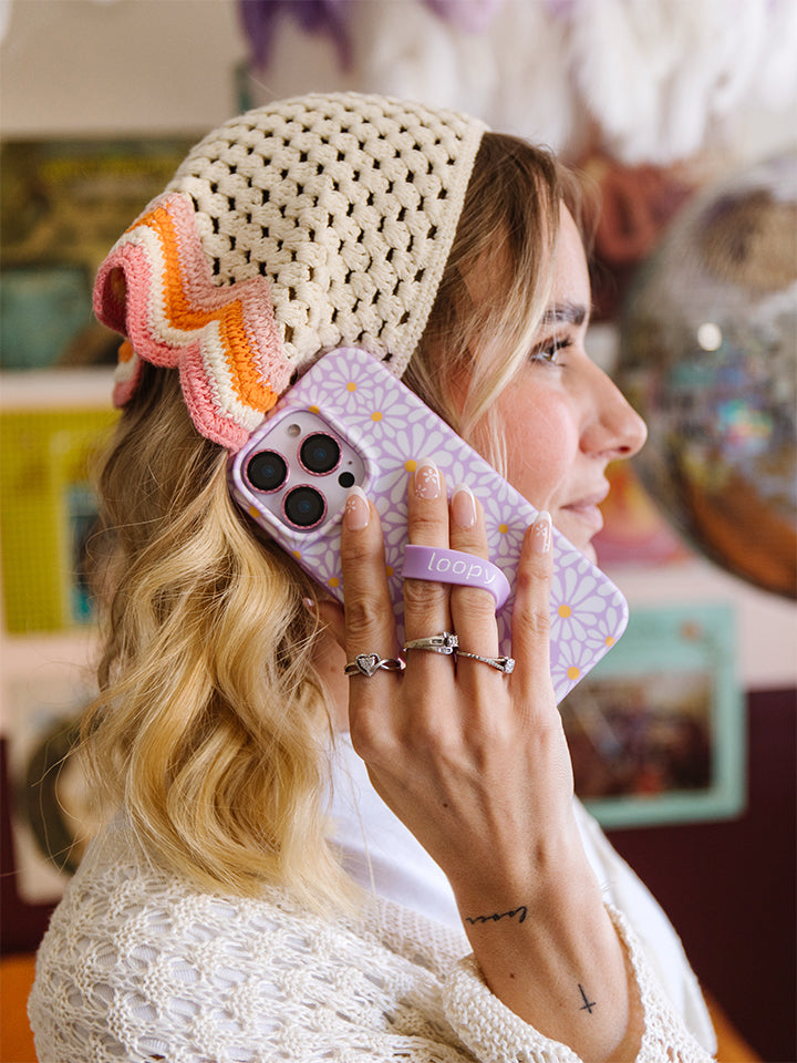 A woman holding a Daisy Daze Loopy Case. || feature-media