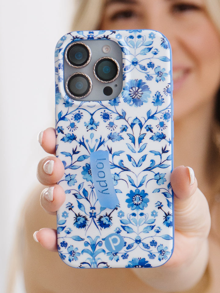 A woman holding a Blue Willow Loopy Case. || feature-media