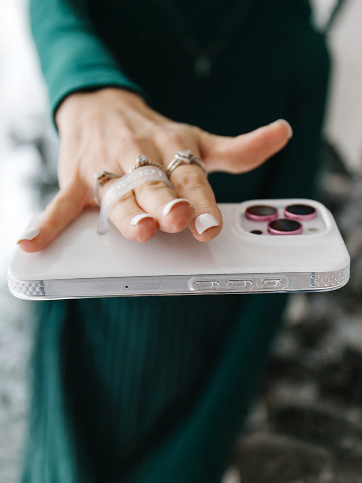 A woman holding a White Shimmer Loopy Case. || feature-media