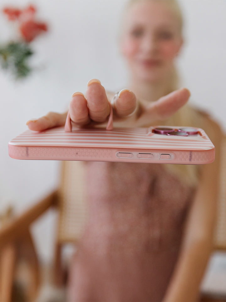 A woman holding a Terracotta Stripes Loopy Case. || feature-media