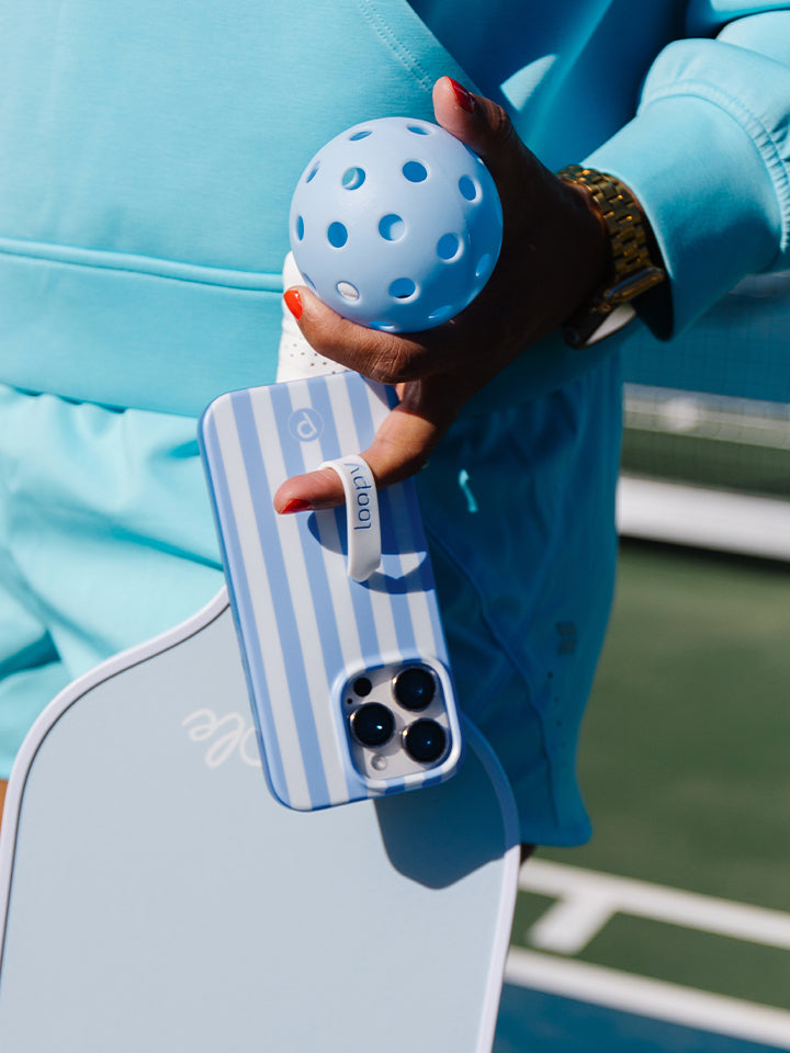 A woman holding a Blue Stripes Loopy Case. || feature-media