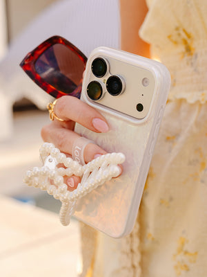 A woman holding a Sunkissed Shores Loopy Case. || feature-media